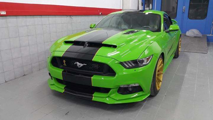 Πράσινο Ford Mustang με μαύρες ρίγες και χρυσές ζάντες στο συνεργείο