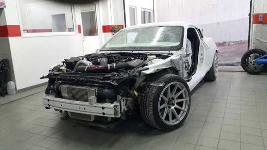 Λευκό Ford Mustang με αφαιρεμένο προφυλακτήρα και τροχό